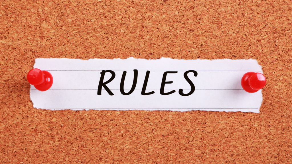 コルクボードに赤いピンで留めた「RULES」と書かれた紙