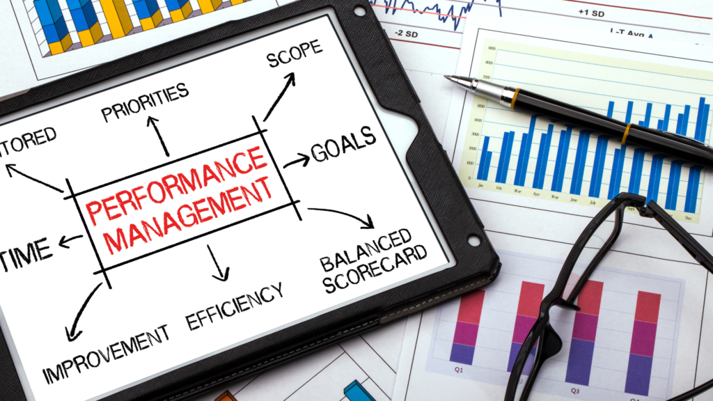 「PERFORMANCE MANAGEMENT」と書かれたタブレットとグラフの資料